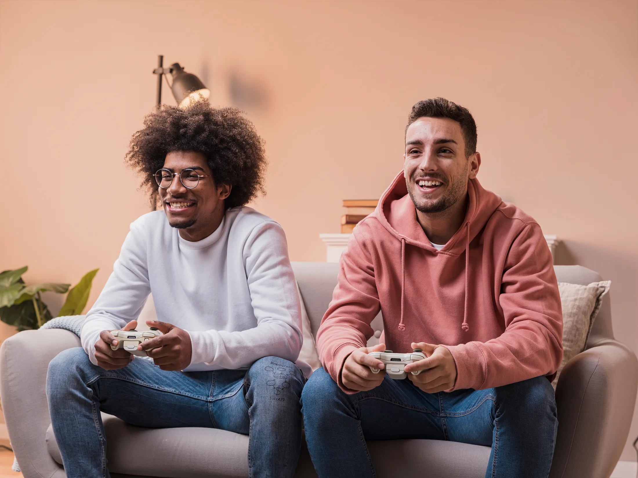 Gaming multijugador sin lag: Dos amigos sonriendo mientras juegan videojuegos online con internet de alta velocidad.