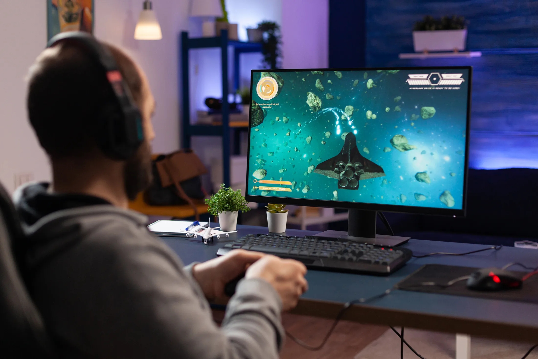 PC gaming setup: Usuario inmerso en un videojuego espacial en su computadora de escritorio.