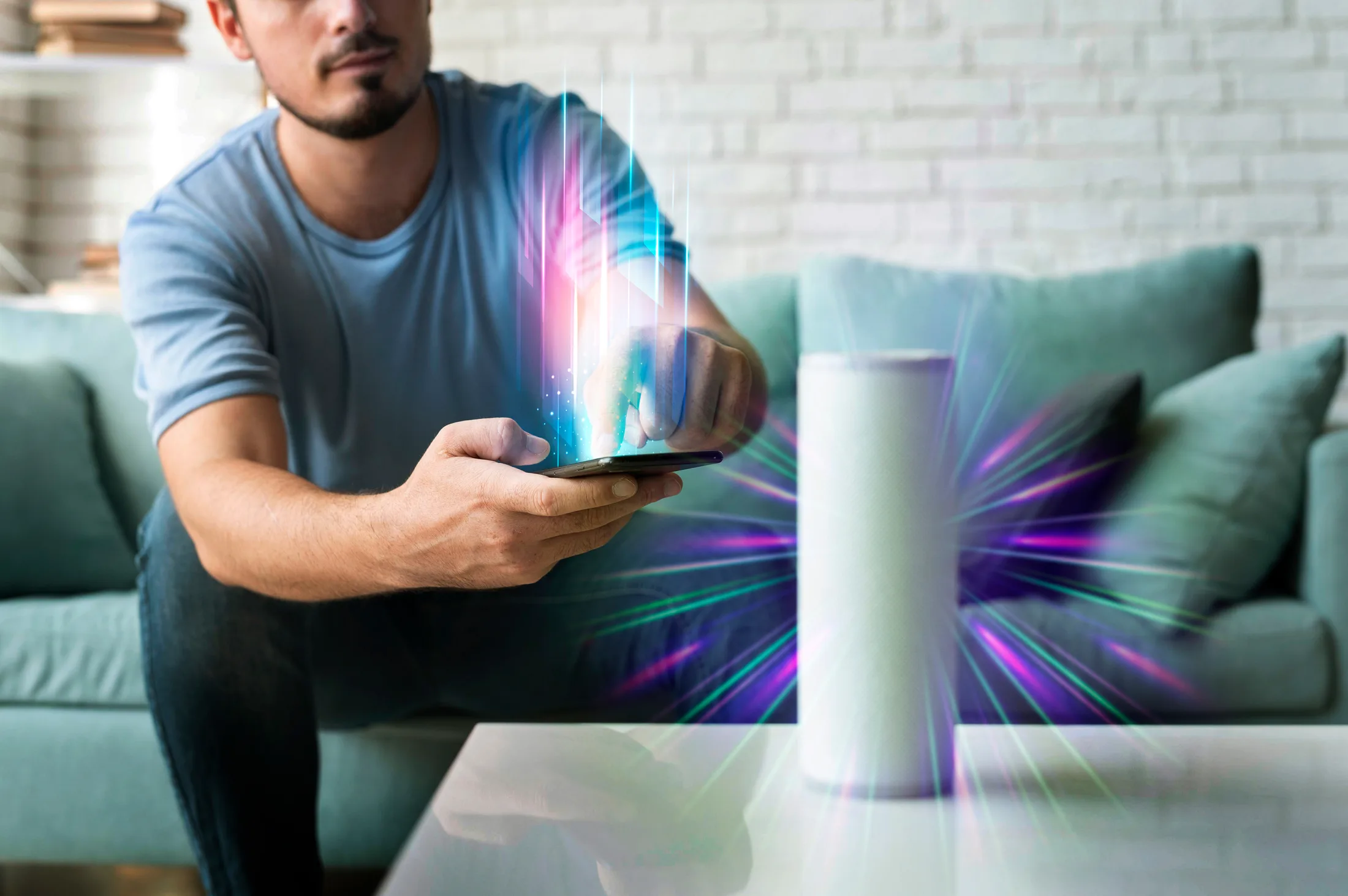 Hombre controlando un smart speaker desde su smartphone en una smart home conectada a internet.