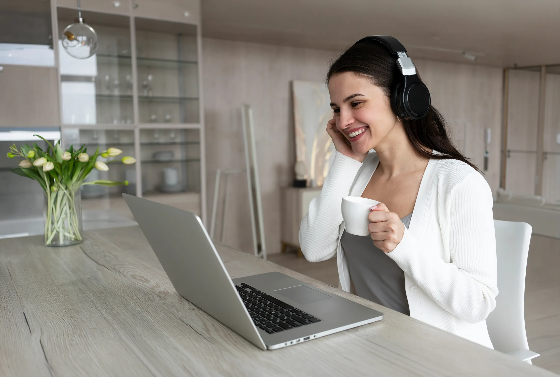Work from home: Mujer sonriendo con audífonos durante una videollamada en su laptop con Wi-Fi estable.